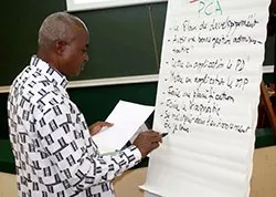 A picture of a teacher in the Coop Academy writing on a board.